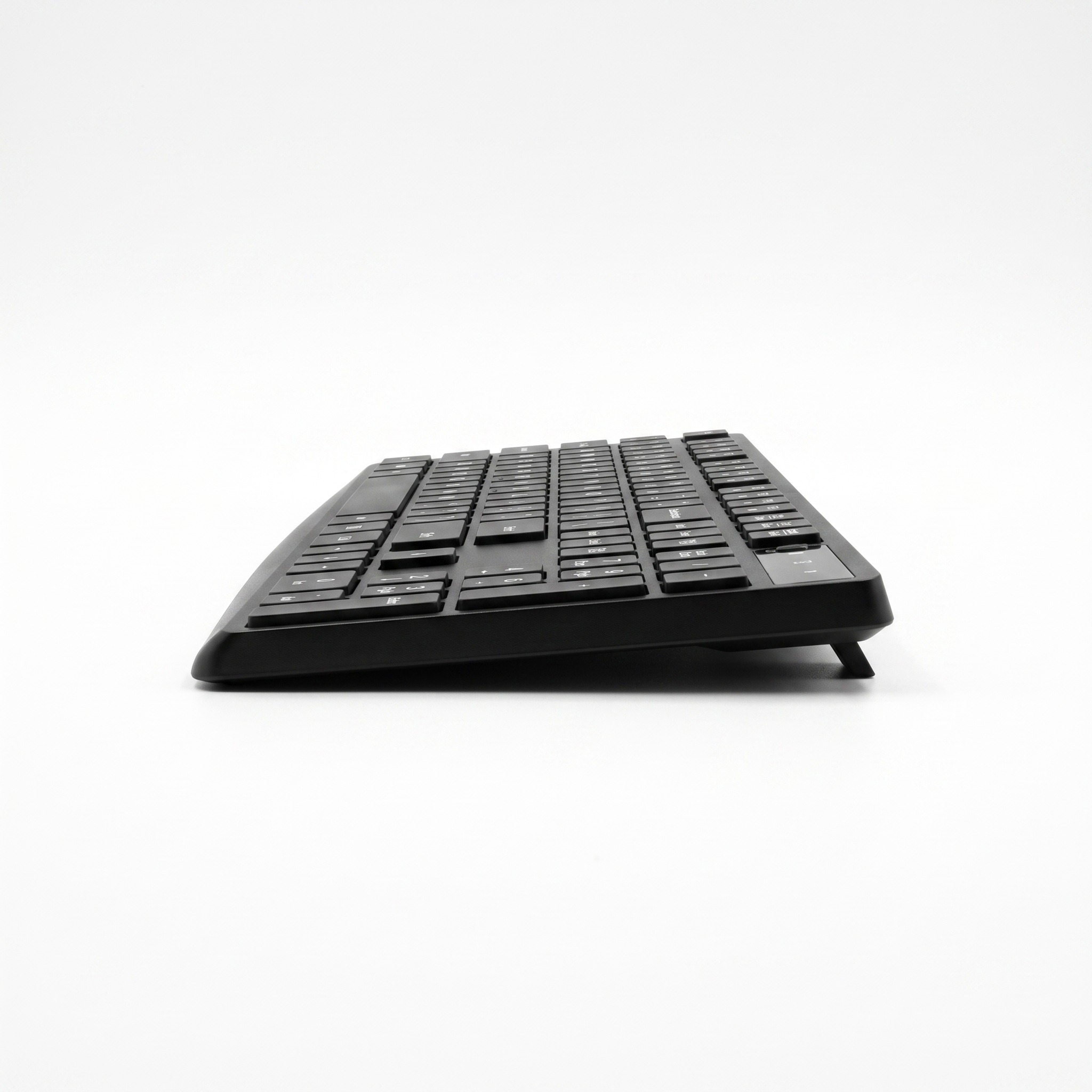 Side profile of the slim wireless keyboard showing its low wedge shape and rear tilt foot