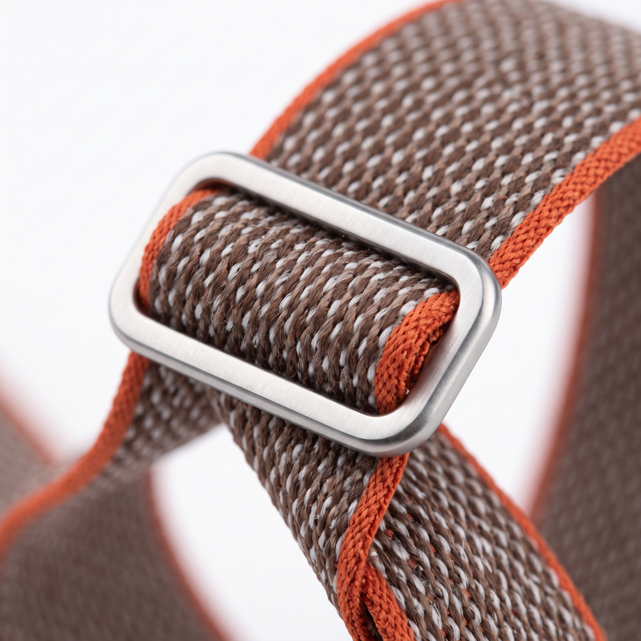 Macro close-up of the brushed metal slider buckle and woven nylon weave of the band